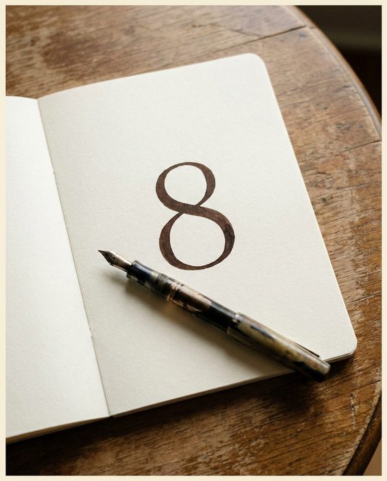 A notebook page with a single large number written in dark ink, a pen laid across it