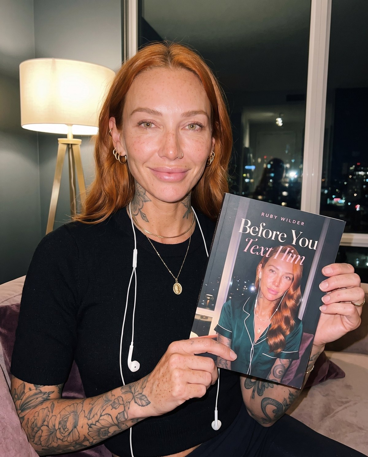 Ruby Wilder at night, headphones in, holding a copy of Before You Text Him.